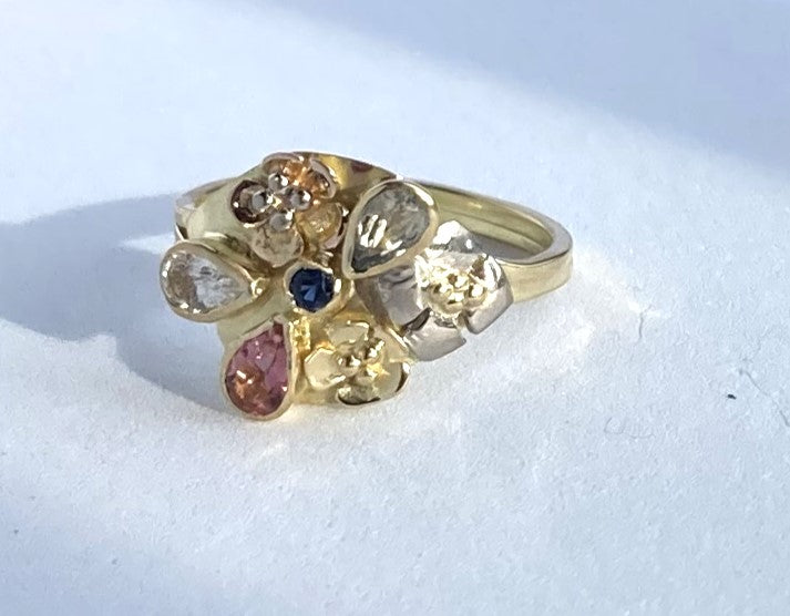 pear shape sapphire and flowers gold cocktail ring, on grey background