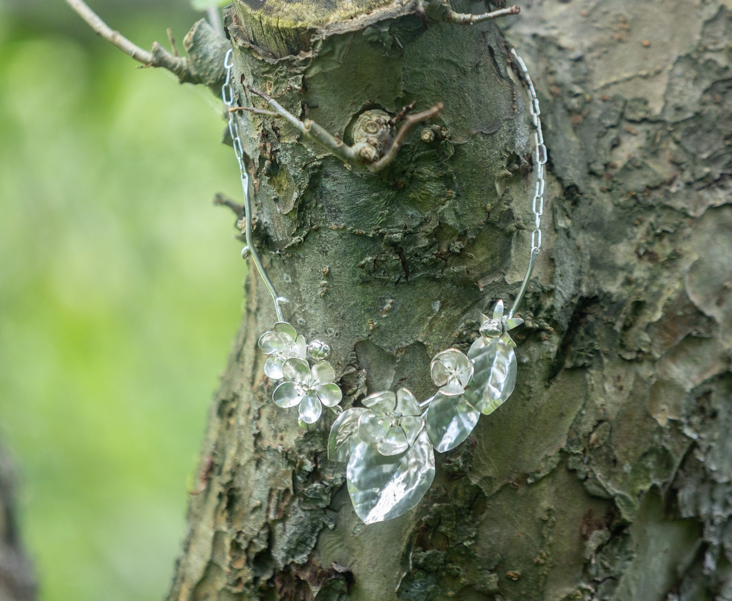 botanical apple blossom and quince flowers statement hand forged bridal necklace on tree bark