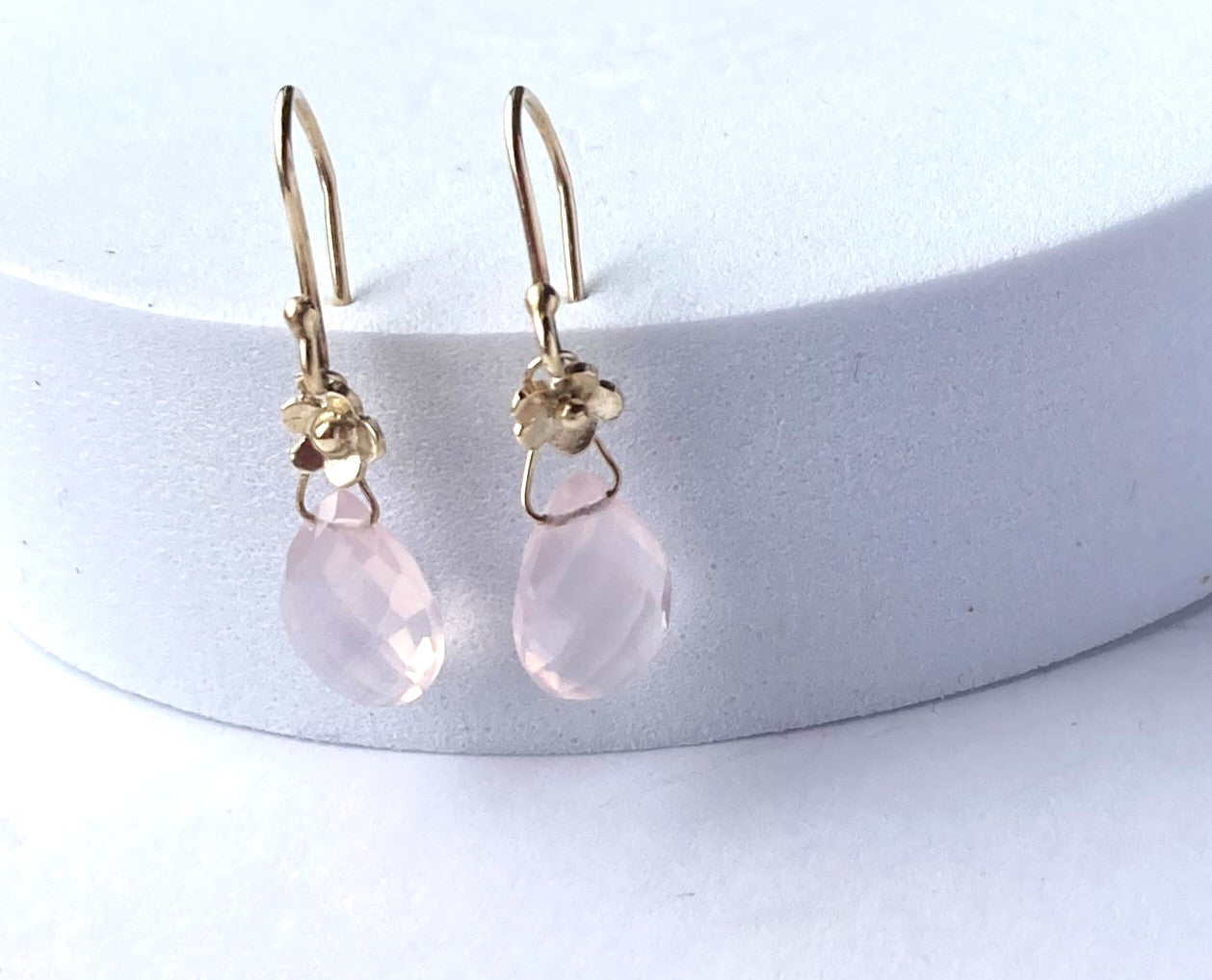 pretty pink rose quartz and gold drop earrings, on white plinth