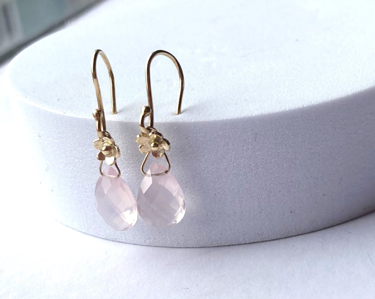 pretty pink and gold drop earrings, stuck into top of white plinth