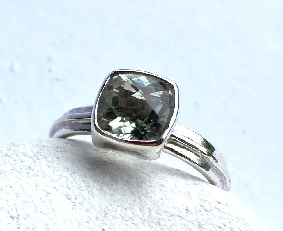 silver ring with large square green amethyst gemstone, white background