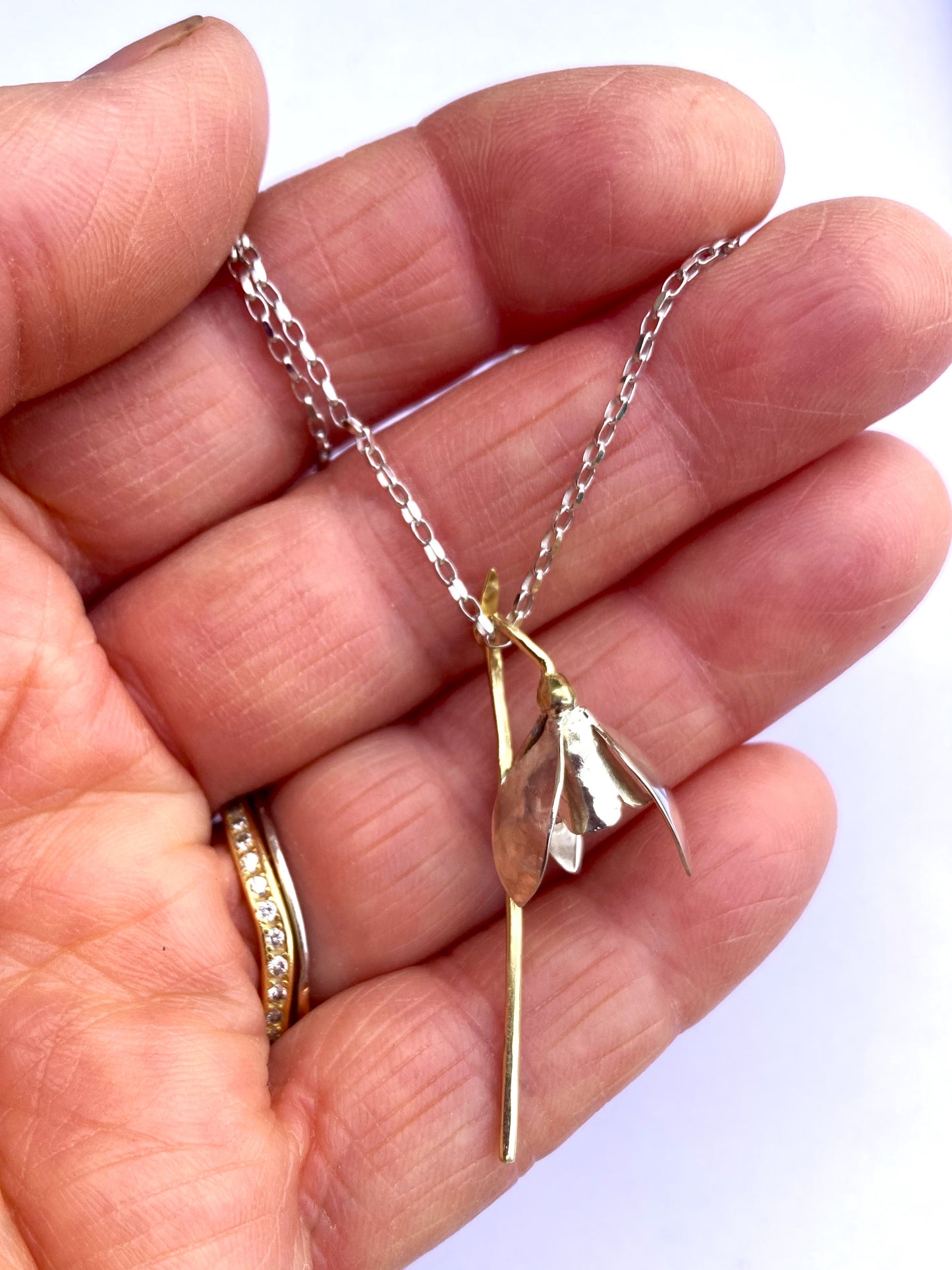 galanthus green and white gold snowdrop pendant in hand