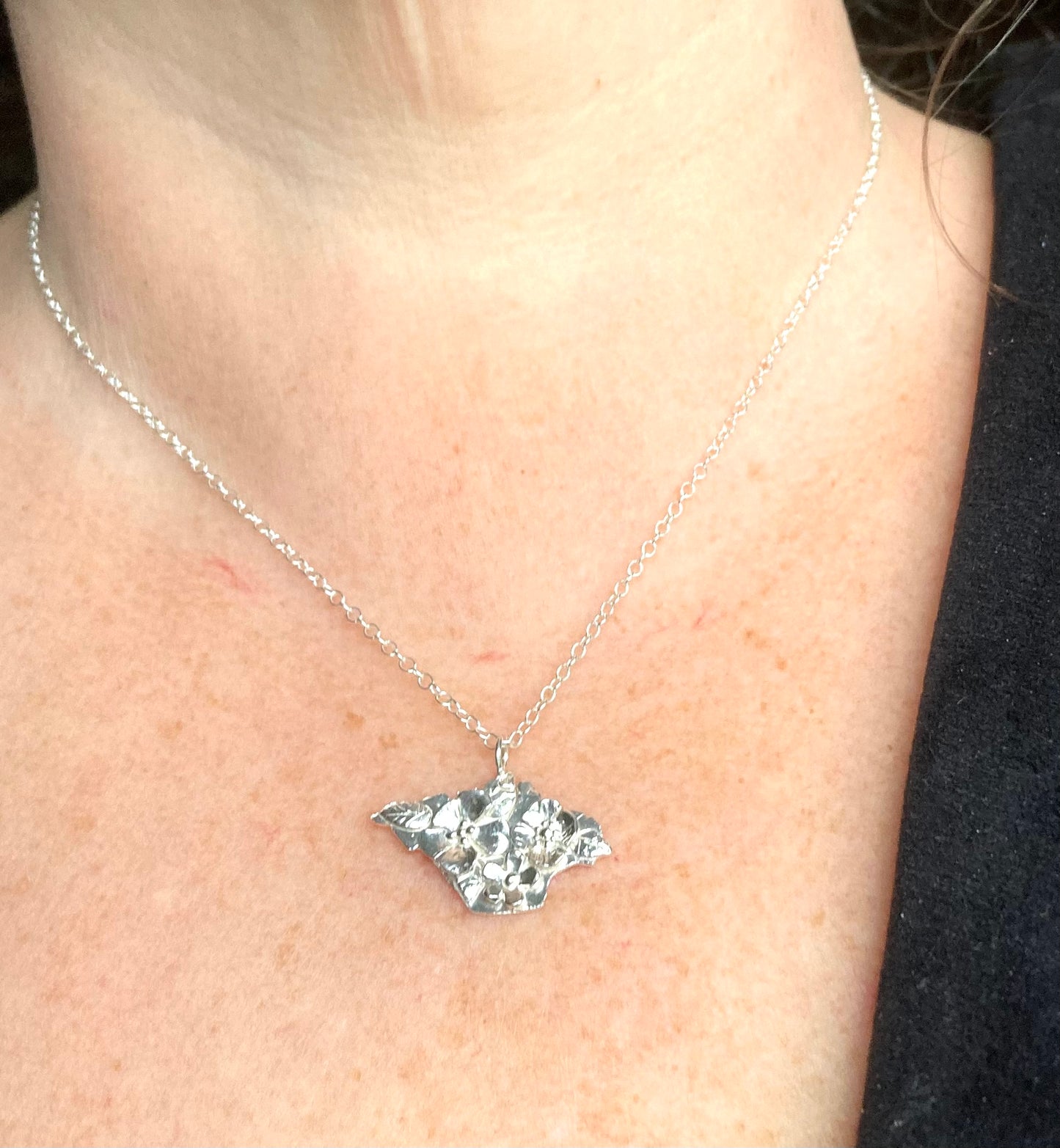 floral Isle of Wight pendant worn on woman's neck