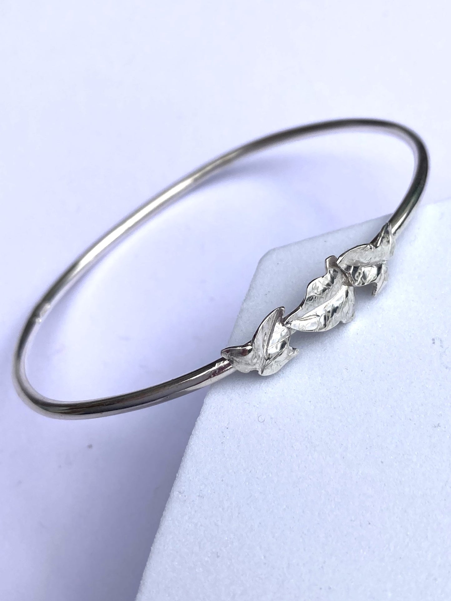 slim bangle with three detailed ivy leaves, on grey background