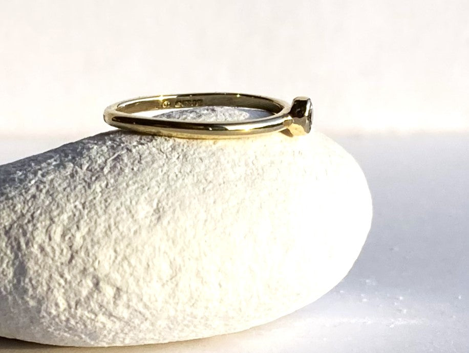 halo band 18ct yellow gold diamond solitaire simple engagement ring on white pebble