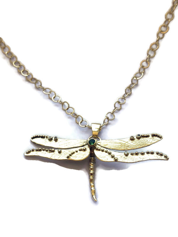 Gold dragonfly necklace on a white background
