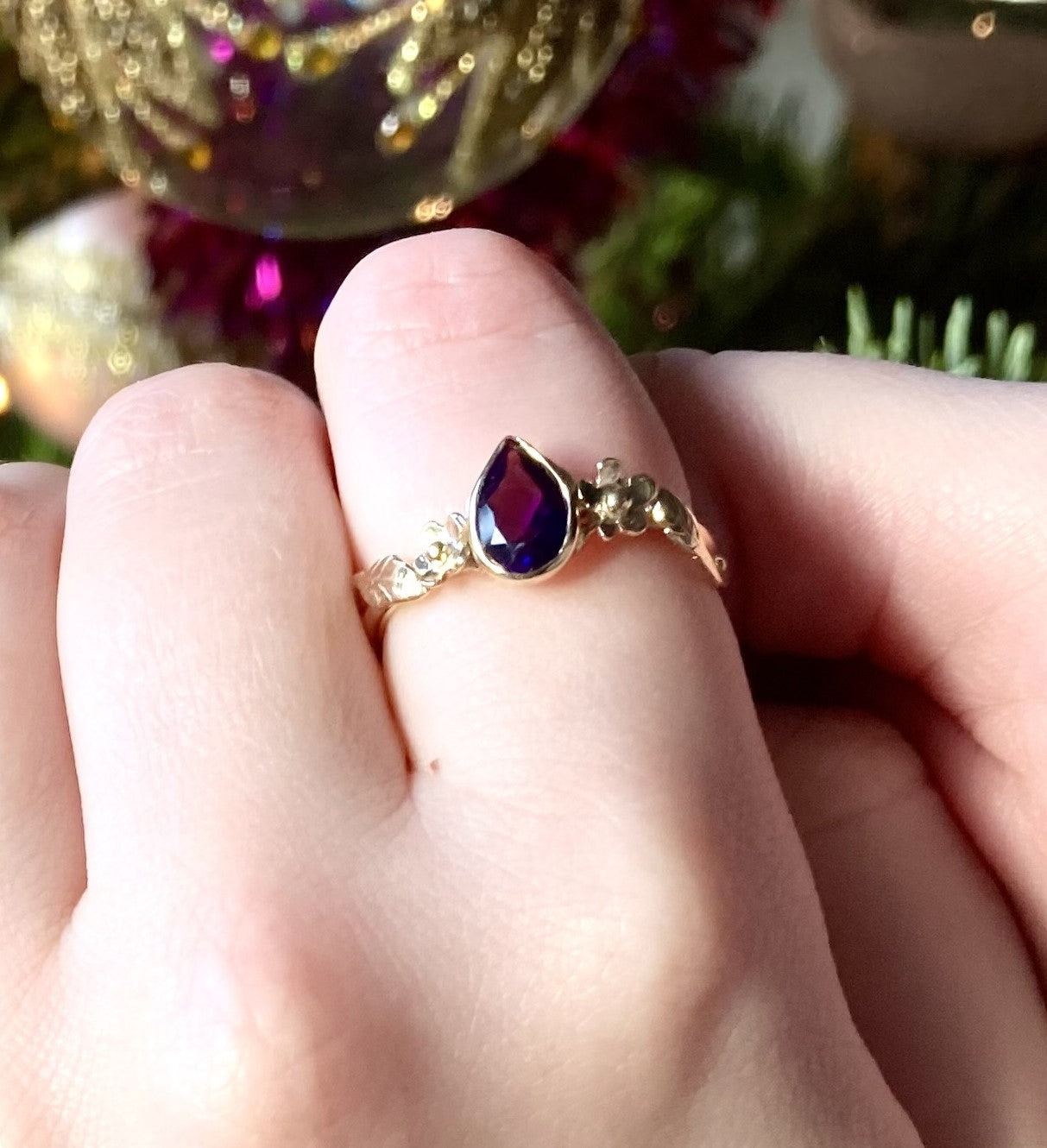 Pear shape dark amethyst gold floral ring, on finger