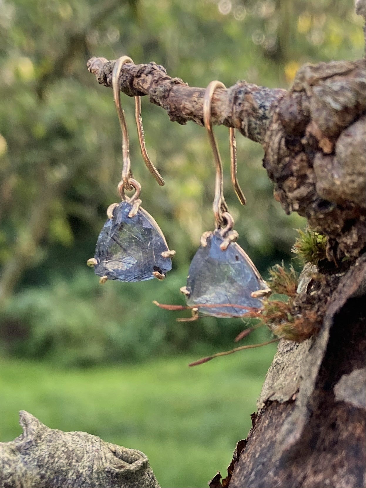 gold drop earrings set with triangle rutilated quartz hanging on twig