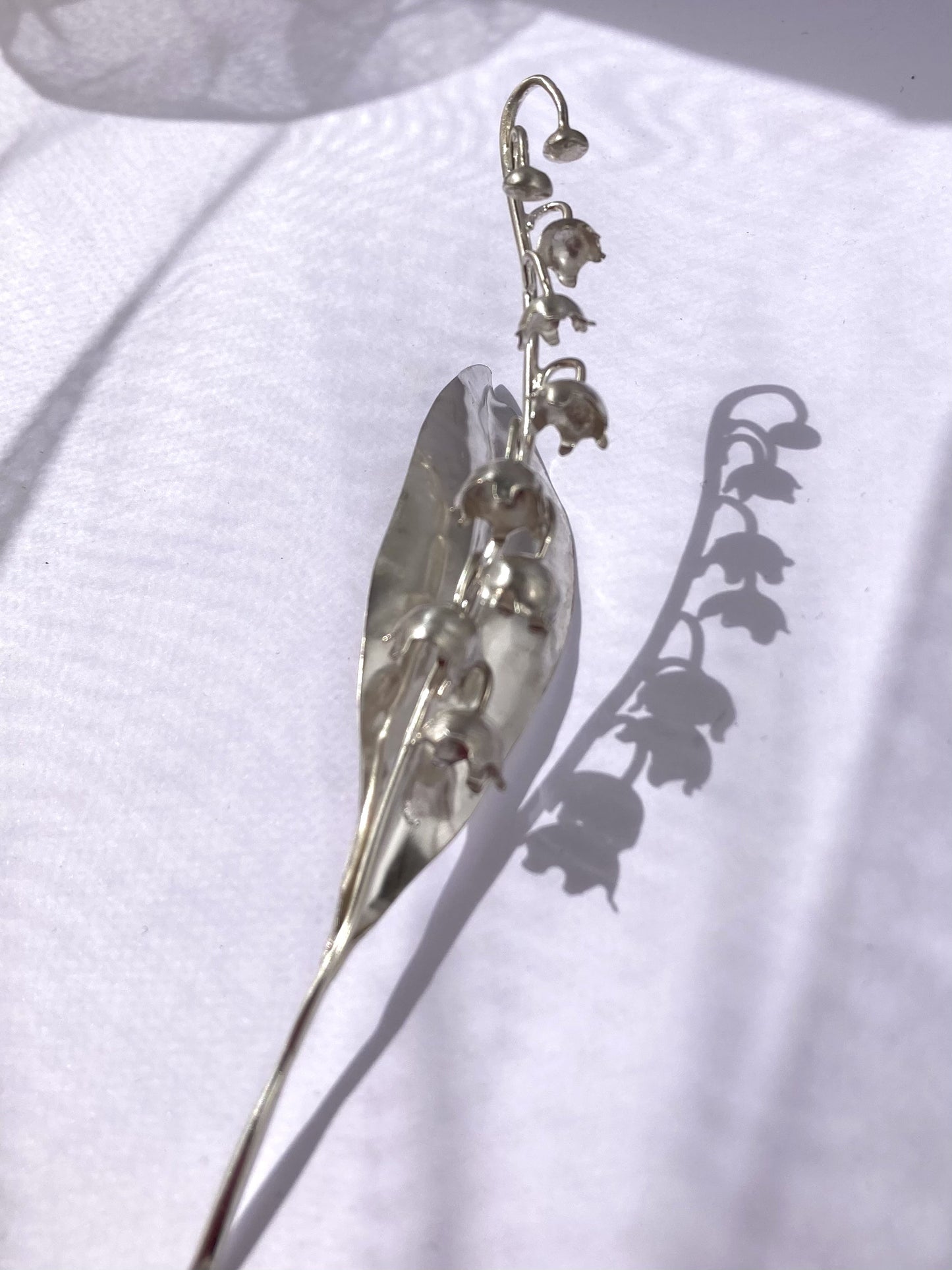 silhouette and shadow of lily of the valley flower in silver