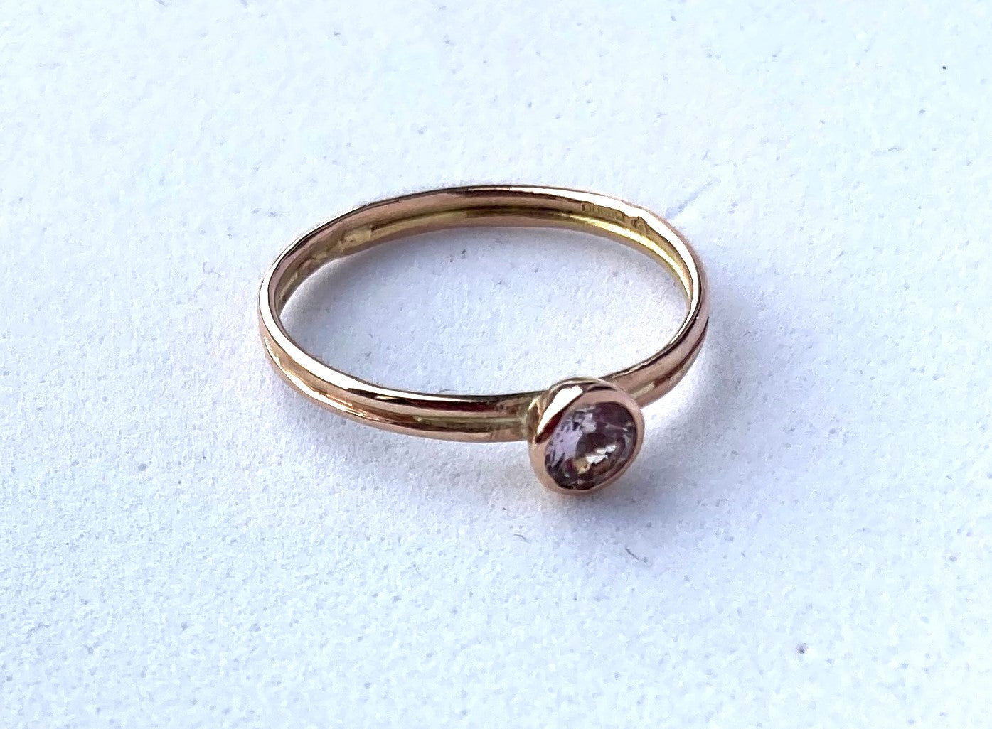handmade rose gold solitaire engagement ring set with pink morganite, on white background