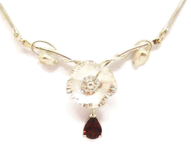 ornate hand forged poppy theme necklace with large pear shape garnet gemstone, on white background