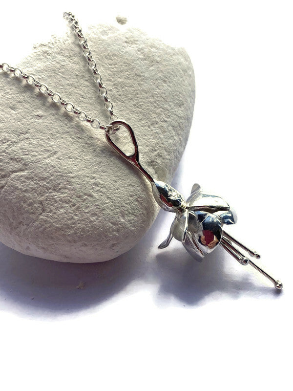 handmade botanical fuchsia pendant on white pebble