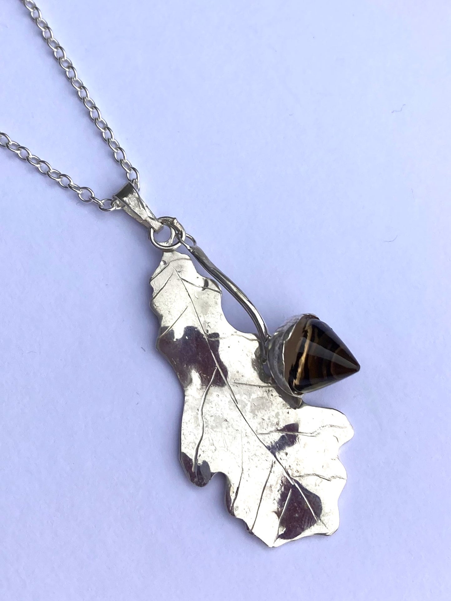 hand made oak and acorn necklace on grey background
