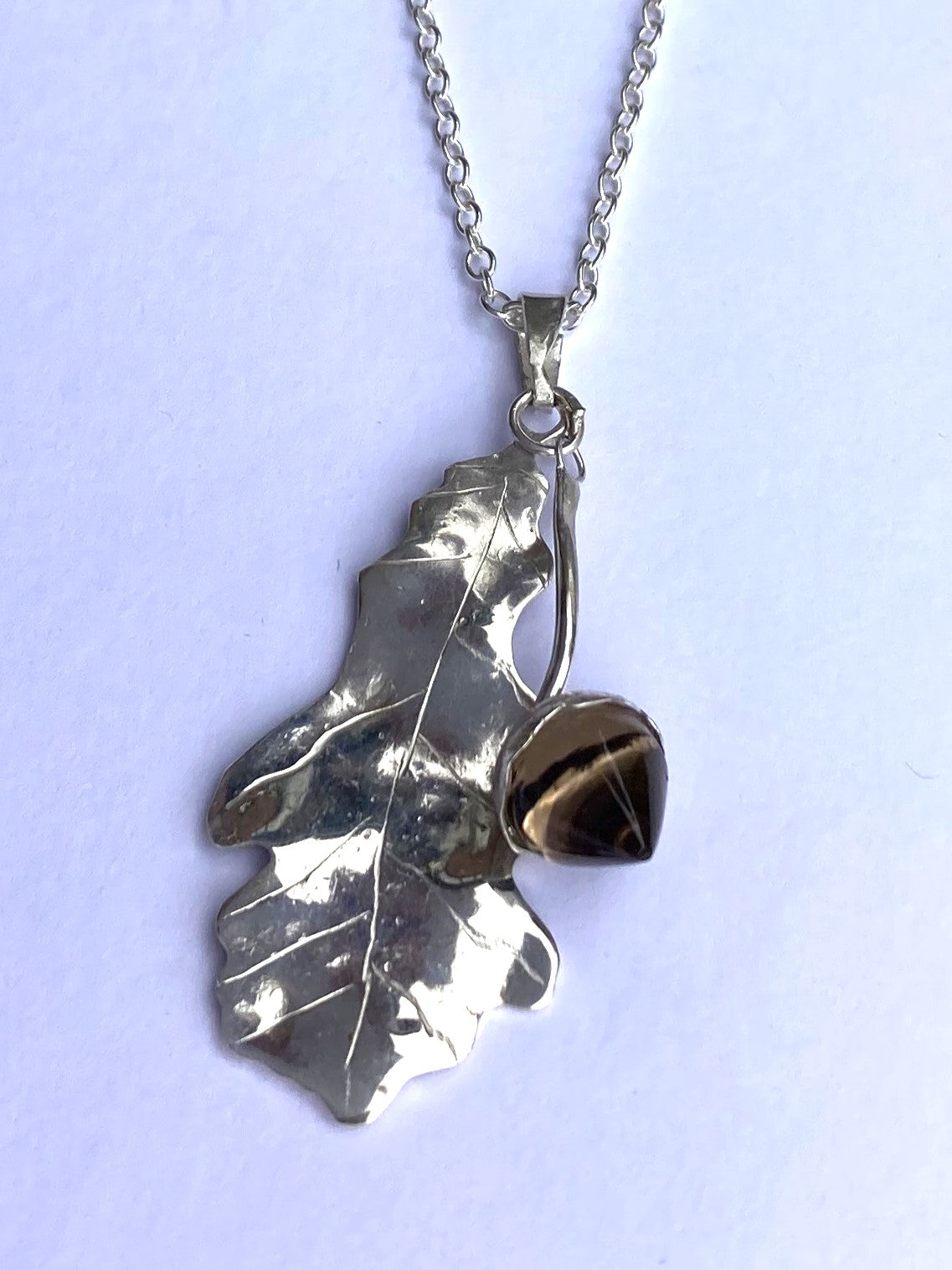 Smokey quartz acorn and oak leaf pendant in sterling silver on grey background