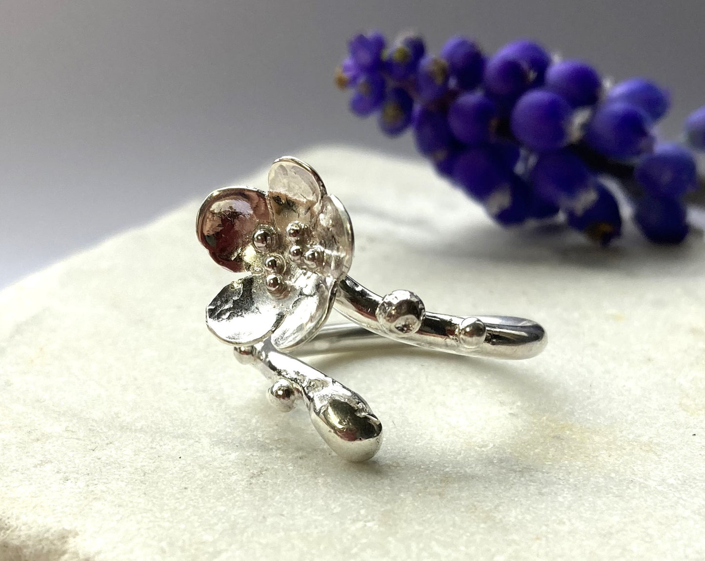 curving silver cherry blossom ring, with real muscari , on marble