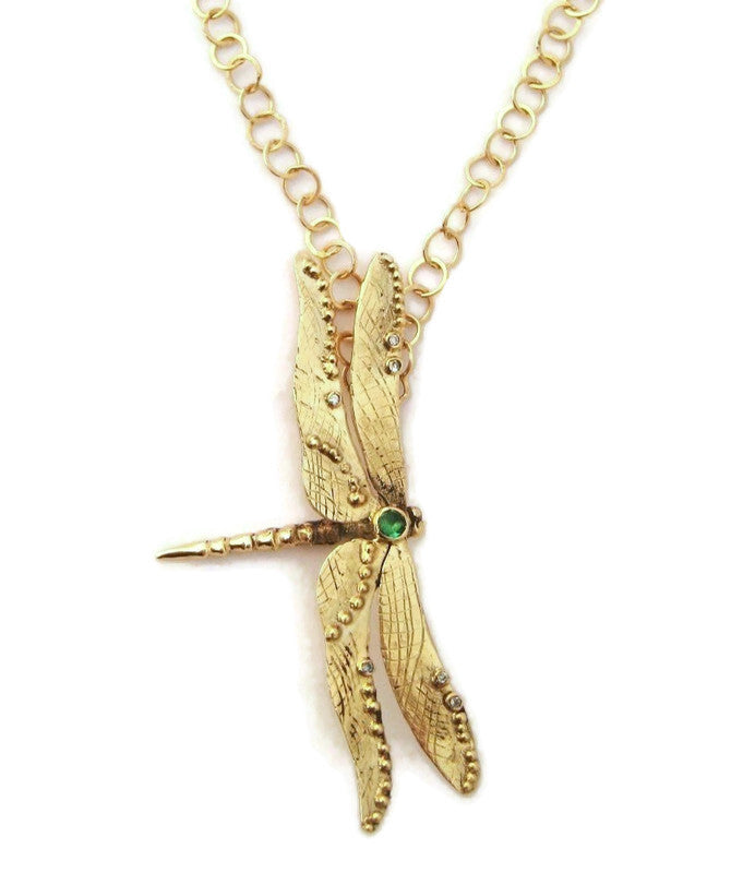 yellow gold dragonfly pendant hanging sideways on a large link gold chain