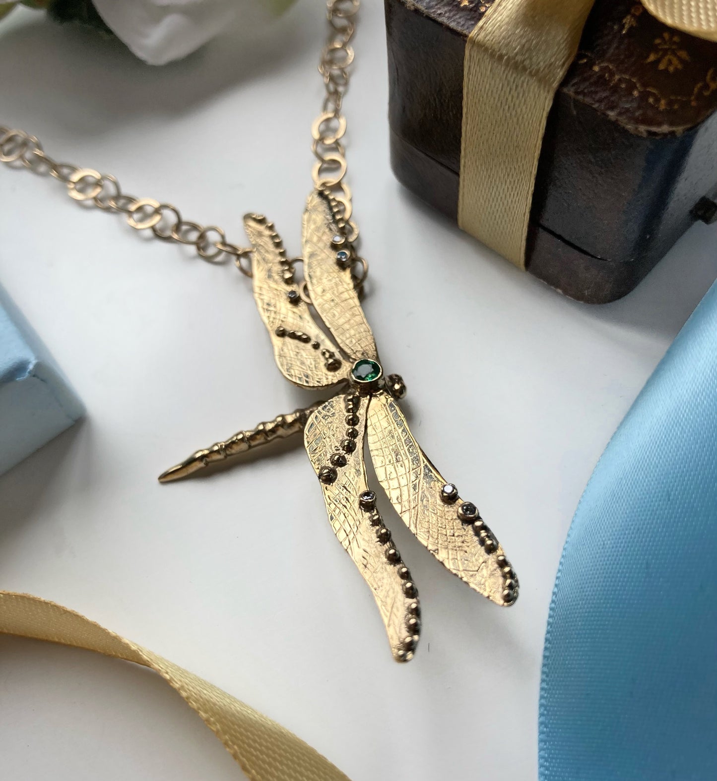 yellow gold dragonfly pendant set with round emerald and small diamonds, on large link gold chain
