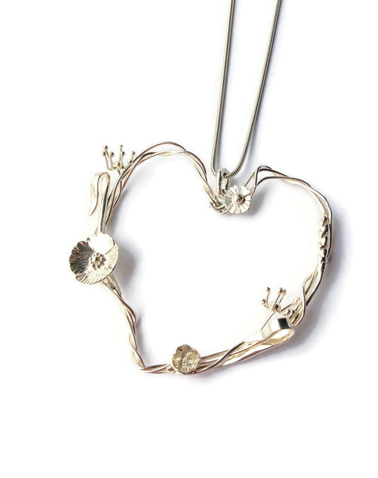 heart shape floral pendant with meadow theme flowers and seedheads in sterling silver, on white background