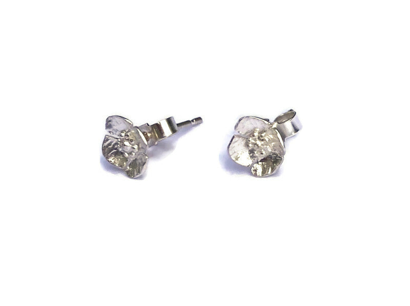 two silver floral stud earrings with scroll backs, on white background