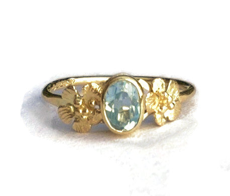 oval blue topaz solitaire yellow gold ring with flowers 