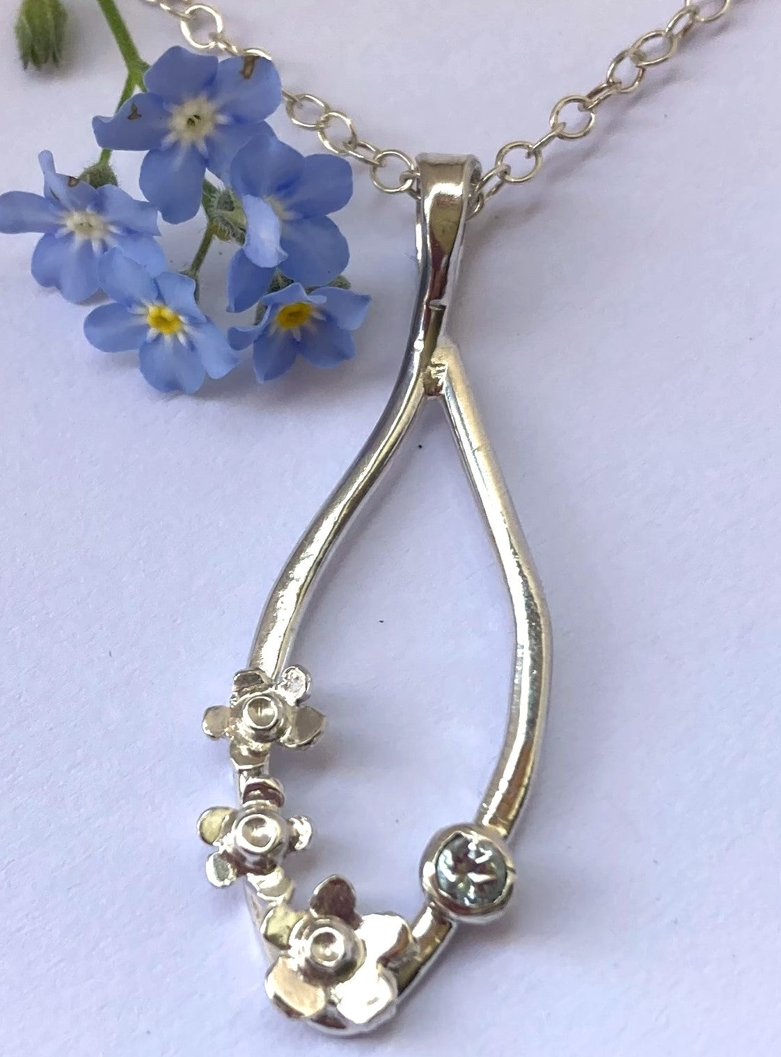 real blue forget-me-not flowers with wire pendant decorated in small flowers with a blue gemstone
