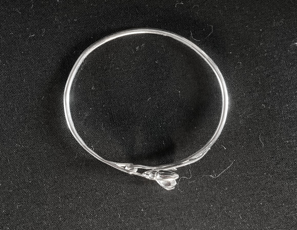 Silver floral bracelet on a black background