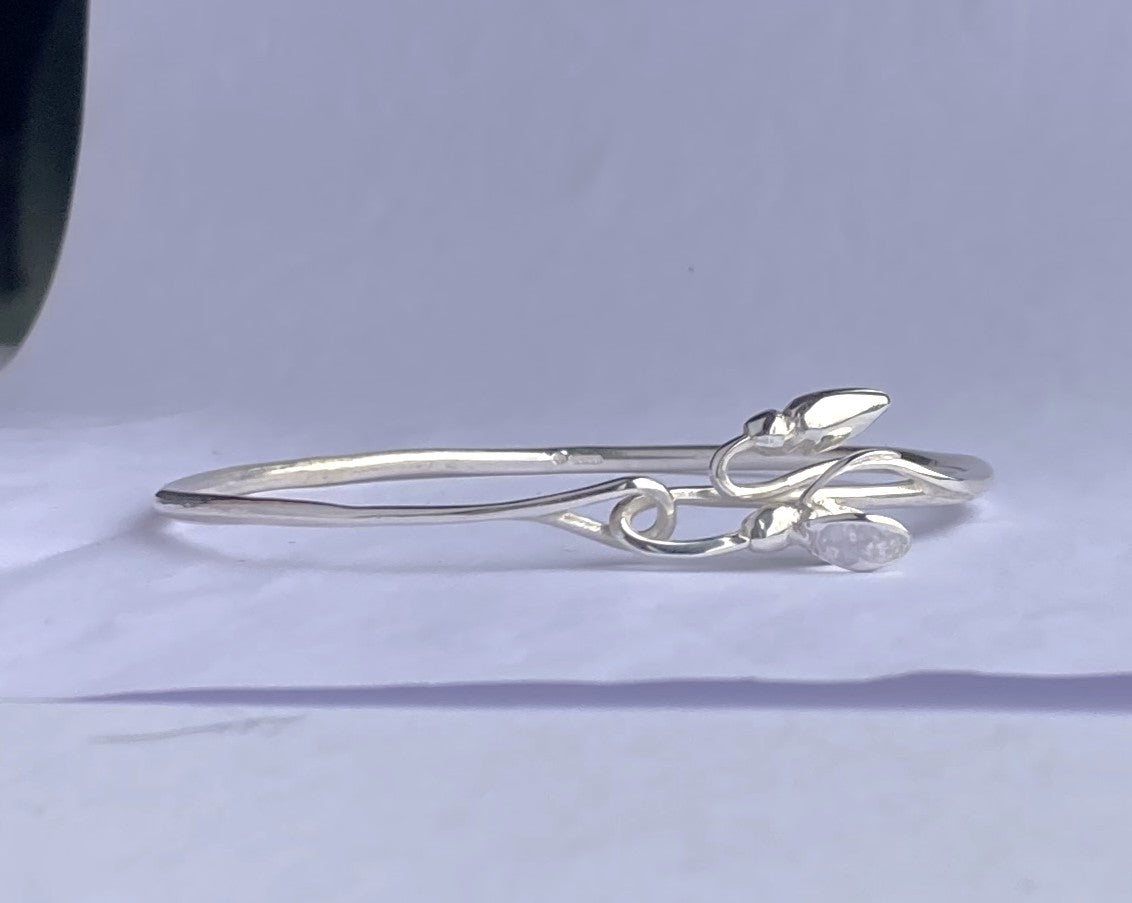 Hand made art nouveau inspired snowdrop bangle by Kim Styles Jewellery on grey background