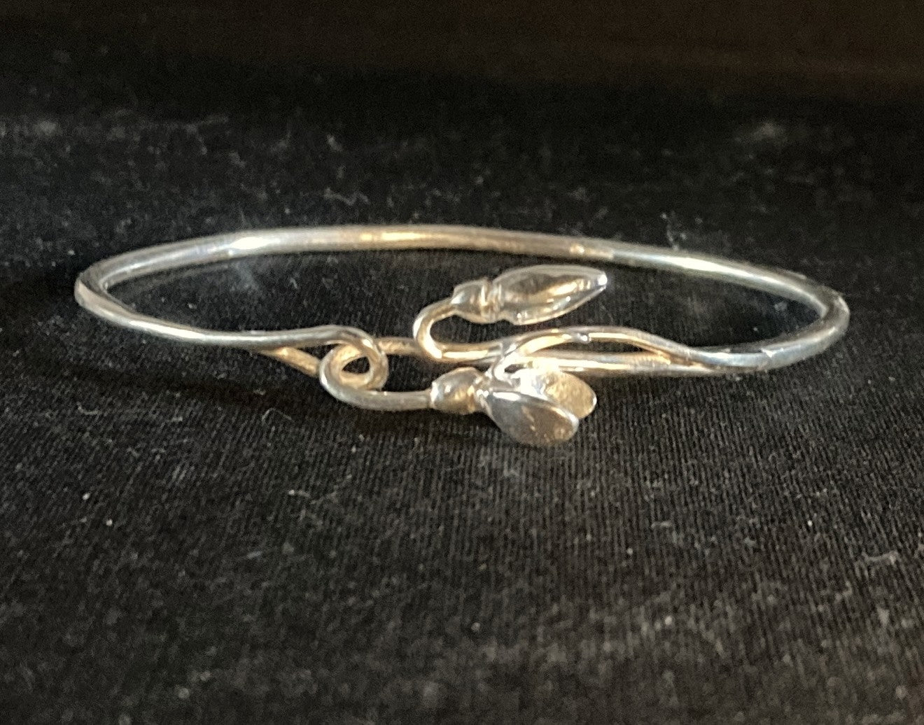Silver bridal bangle with snowdrop design on black background by Kim Styles Jewellery