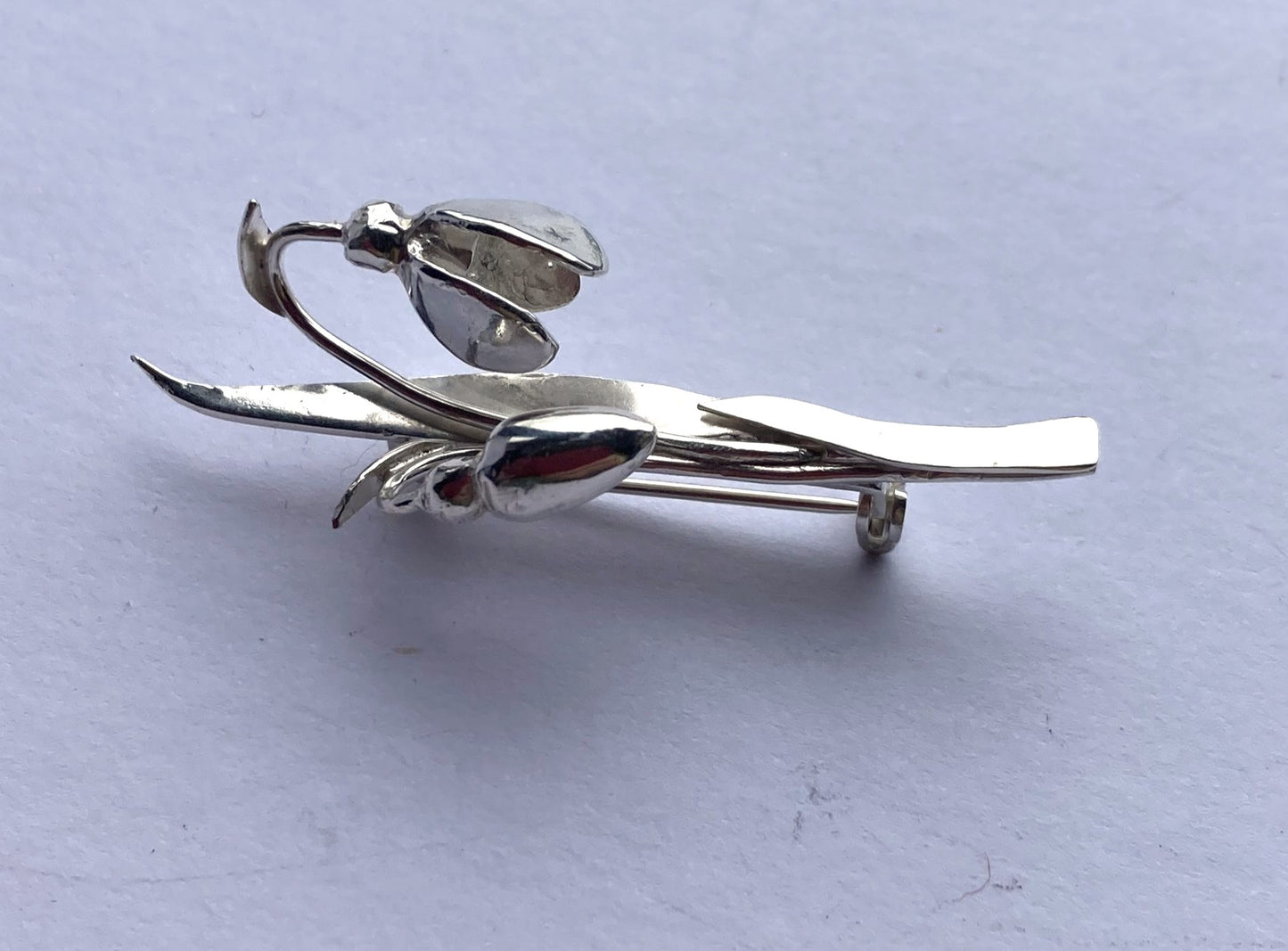 Handmade snowdrop floral silver brooch by Kim Styles Jewellery on a light grey background