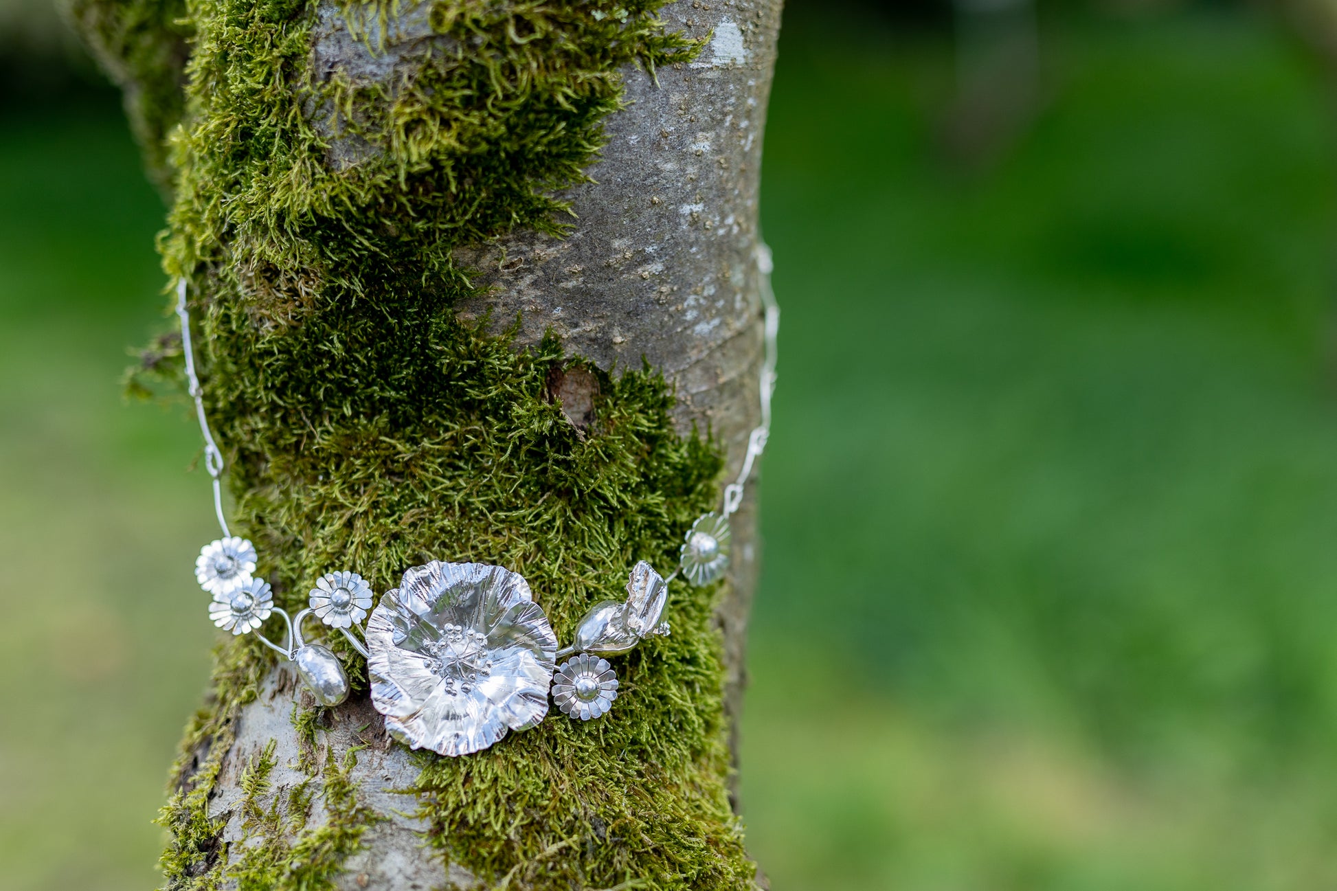 botanical poppy and daisy statement necklace on mossy tree