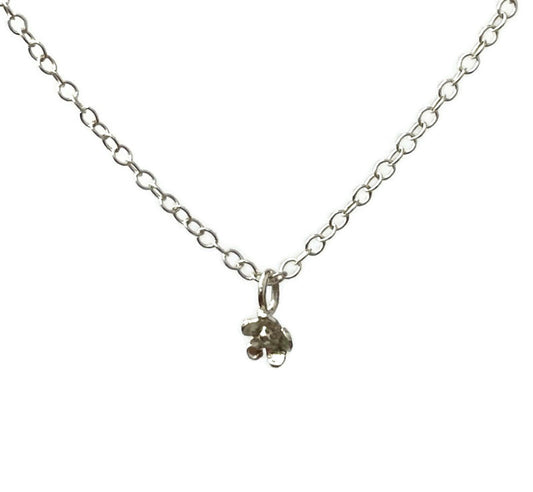 Tiny silver daisy pendant and chain on white background