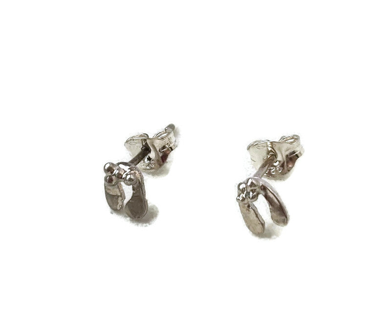 two tiny silver mistletoe stud earrings on white background