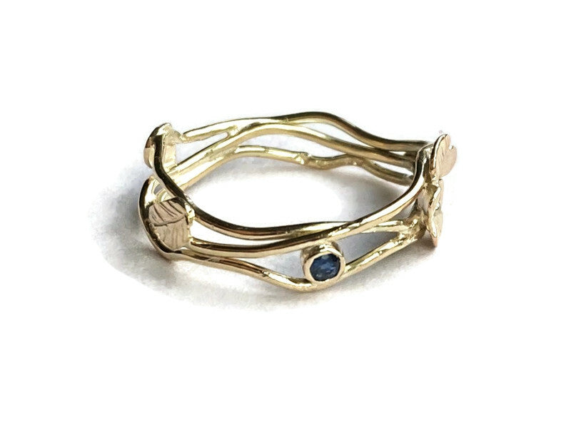 openwork gold ring set with a small round blue sapphire 