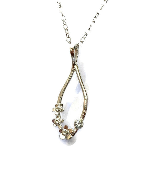 silver wire pendant with three small silver flowers and pale blue gemstone, on white background