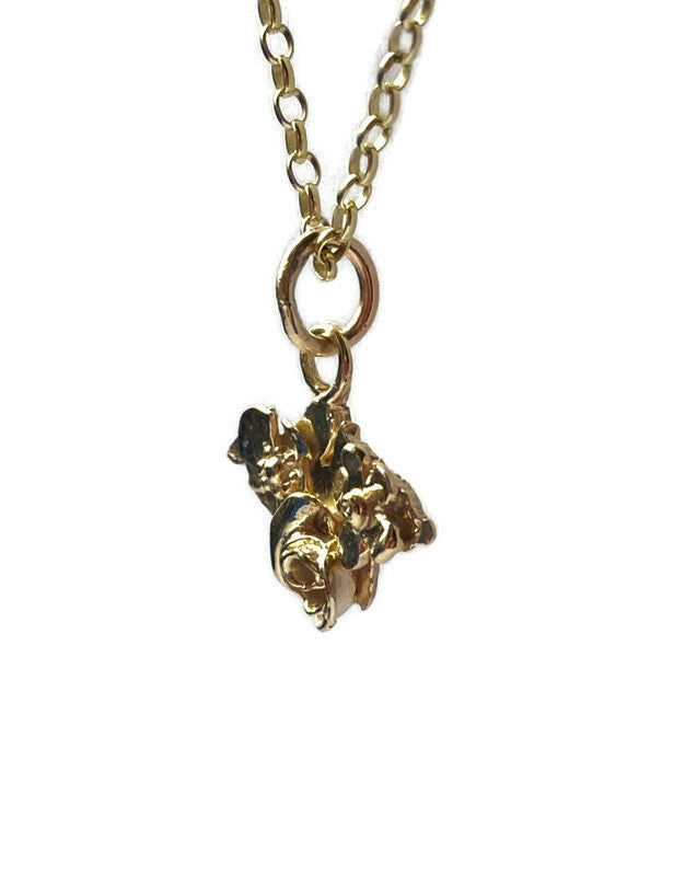 side view of gold Isle of wight floral pendant, on white background