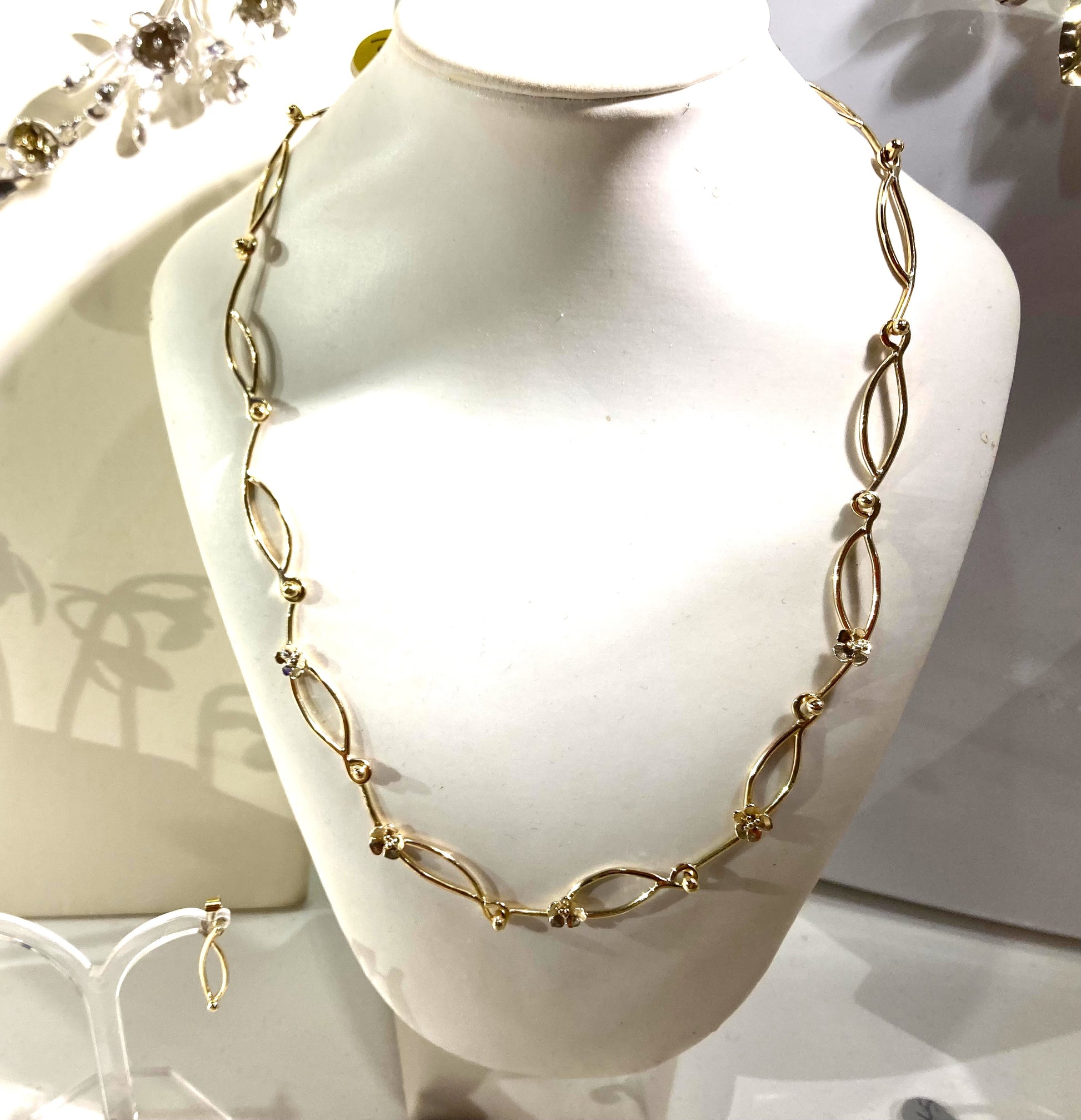 handmade gold daisy chain necklace on white bust