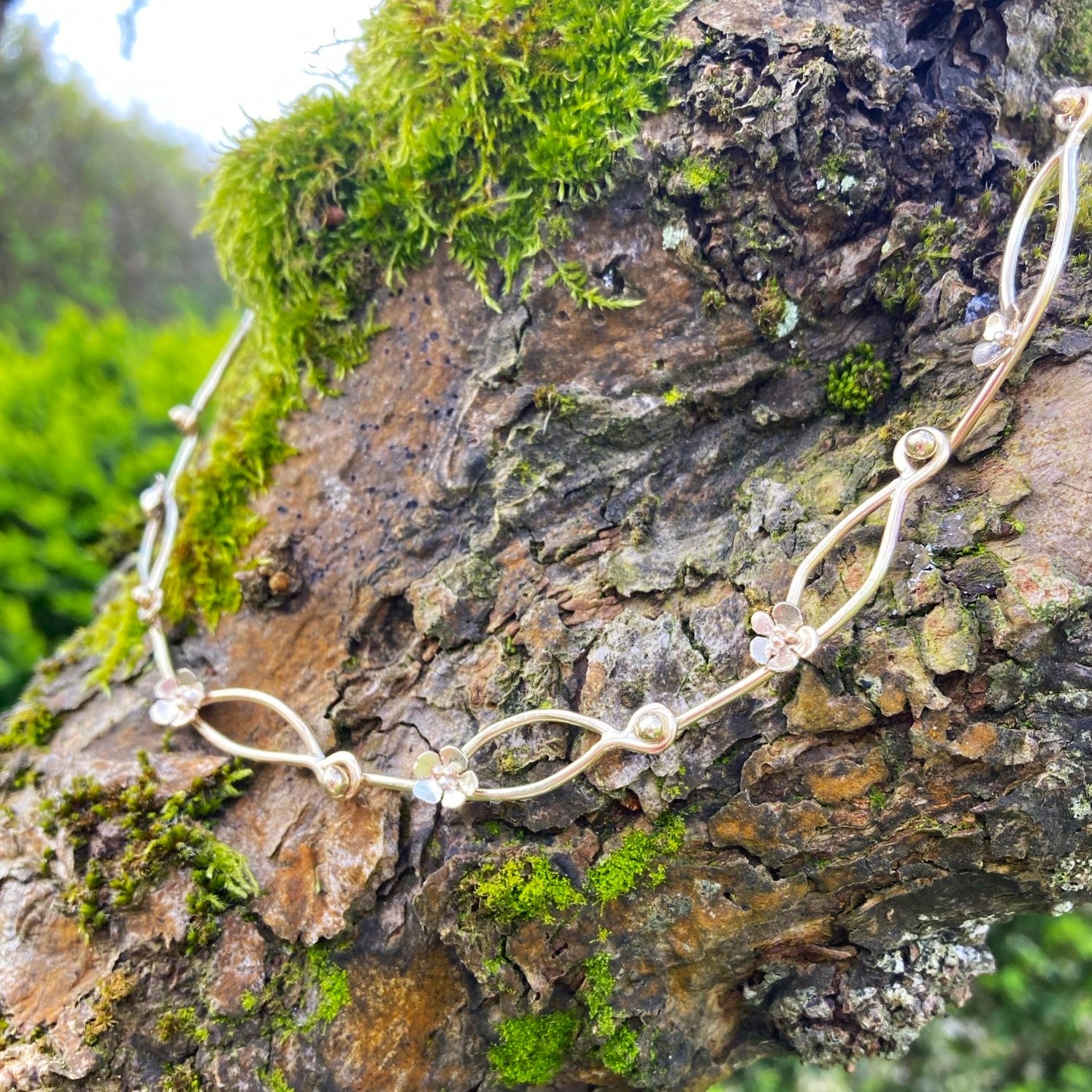 handmade floral gold chain on tree bark