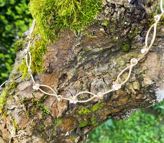 handmade gold daisy chain necklace on mossy tree