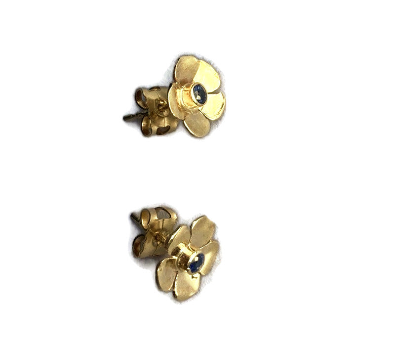 two yellow gold rose shape stud earrings set with blue sapphires on white background