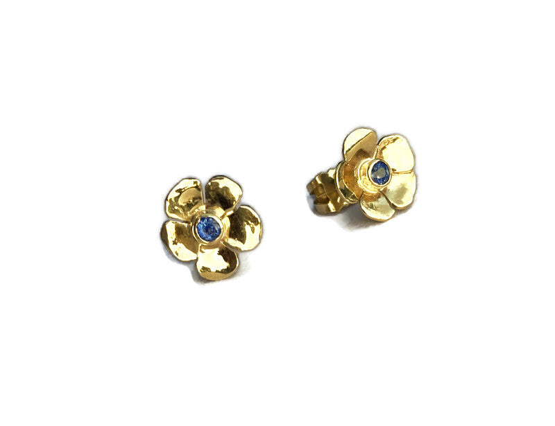 yellow gold flower stud earrings with blue sapphire centers on white background