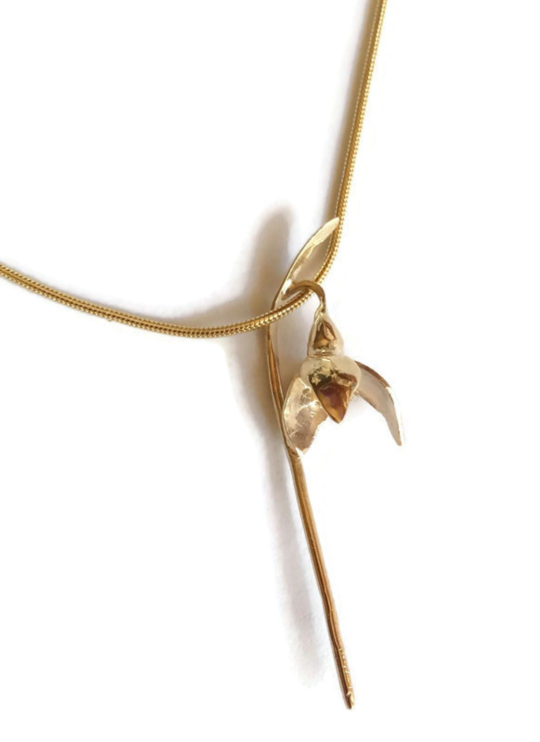 botanical single gold snowdrop pendant on gold snake chain, with white background