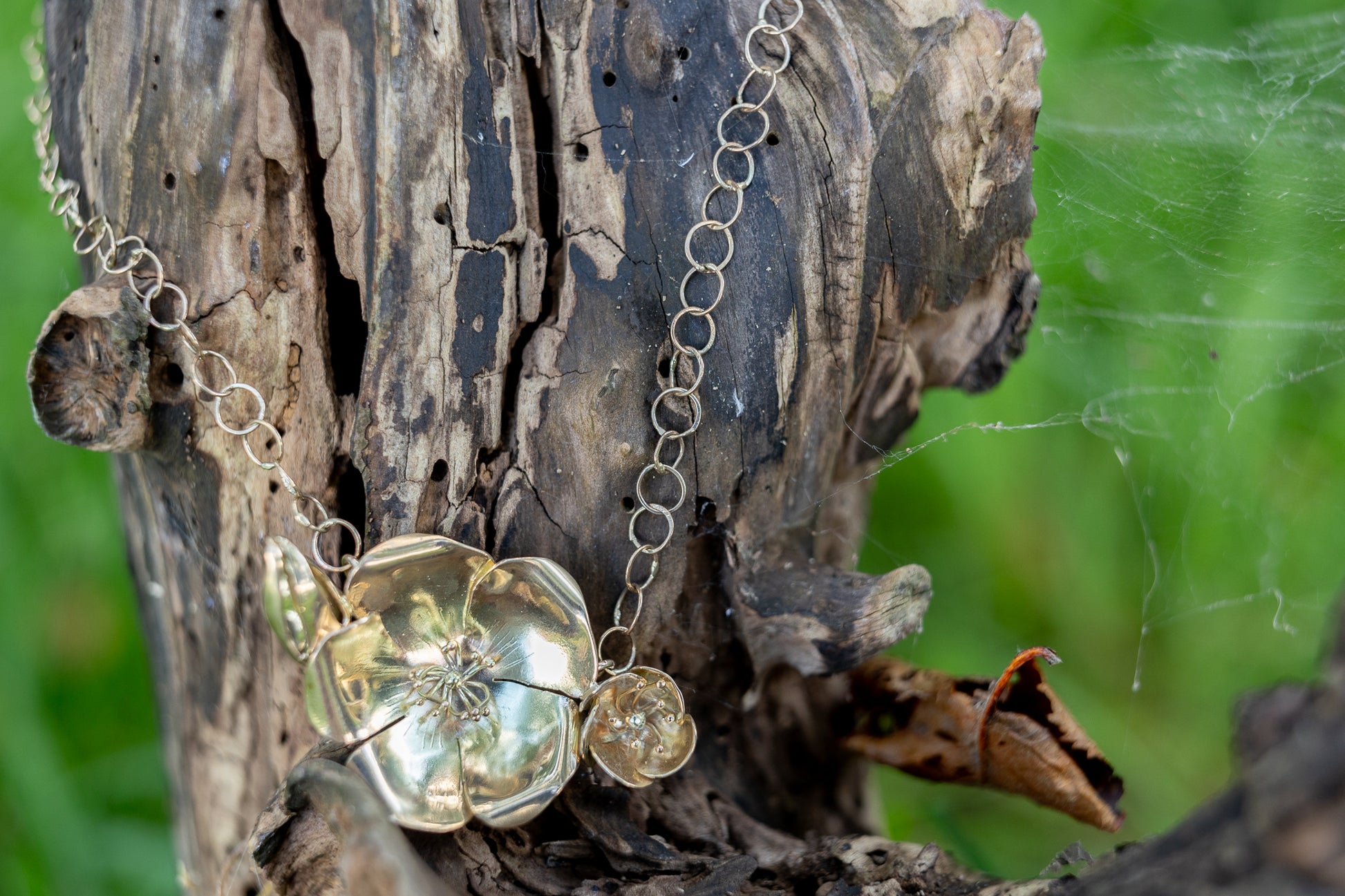 botanical Lifesize gold wild rose pendant necklace and large link gold chain hanging on tree bark