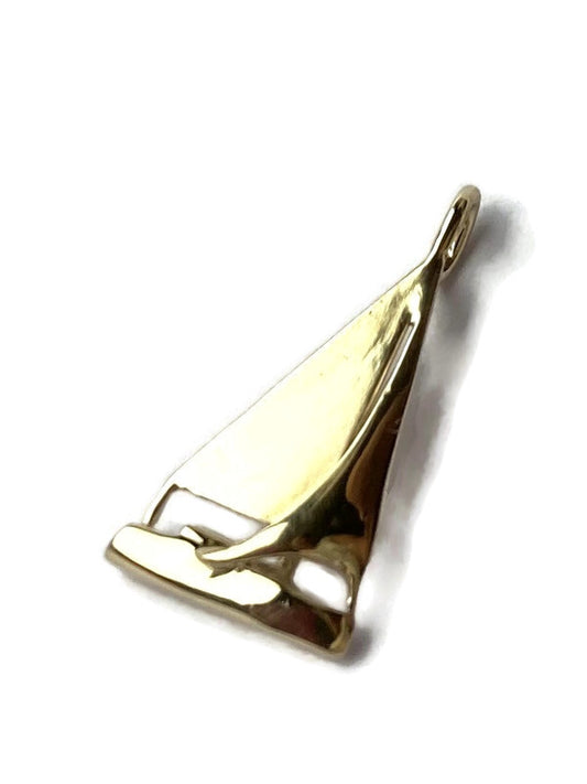 A polished gold pendant shaped like a sailboat, shown on a plain white background with a soft drop shadow.