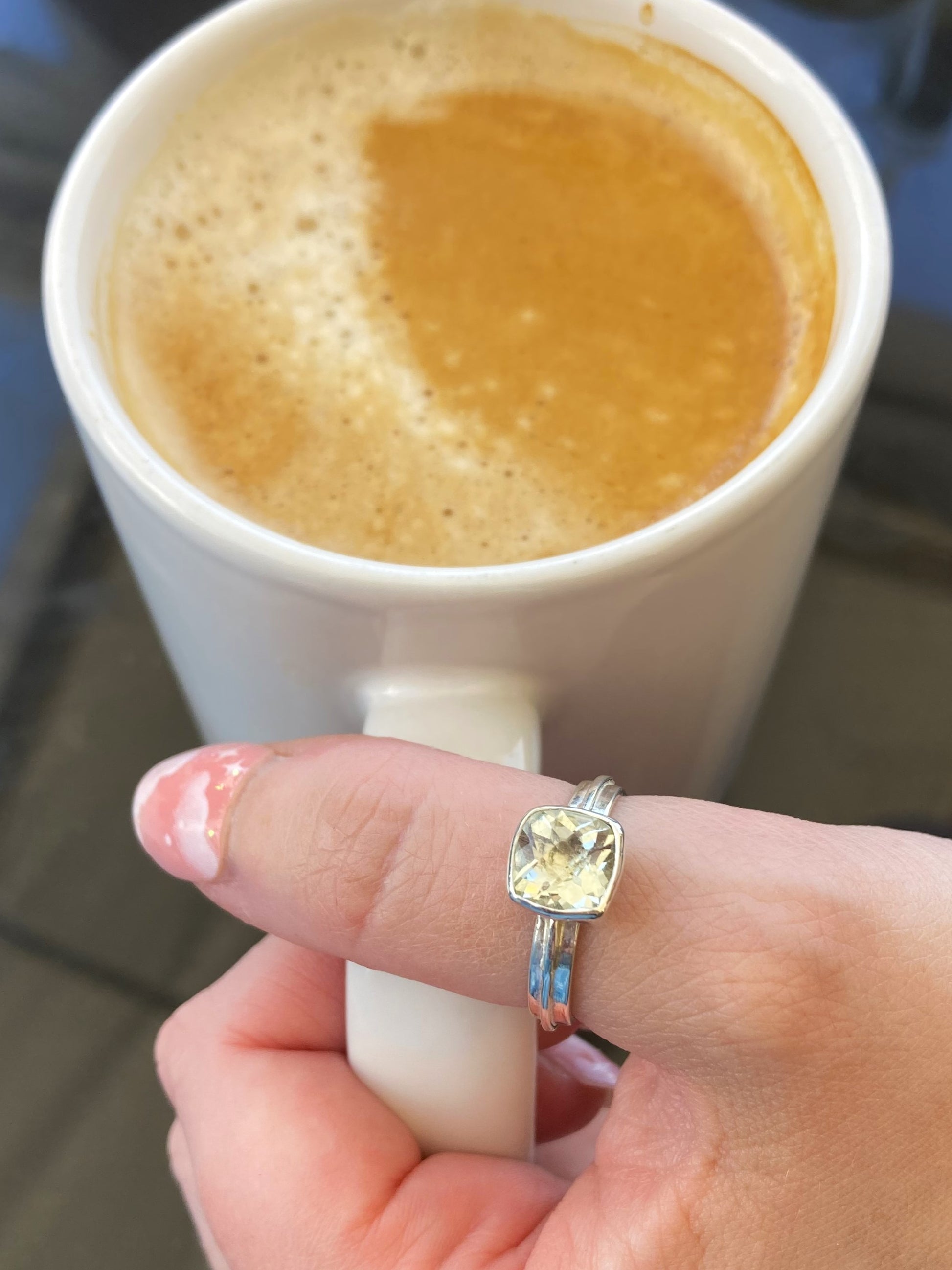 green amethyst square gemstone ring on hand holding mug of coffee