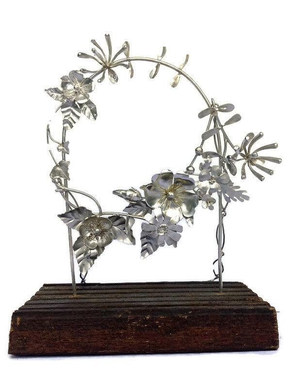 Detailed Hedgerow flowers necklace and stand hand forged in sterling silver by Kim Styles Jewellery, on white background