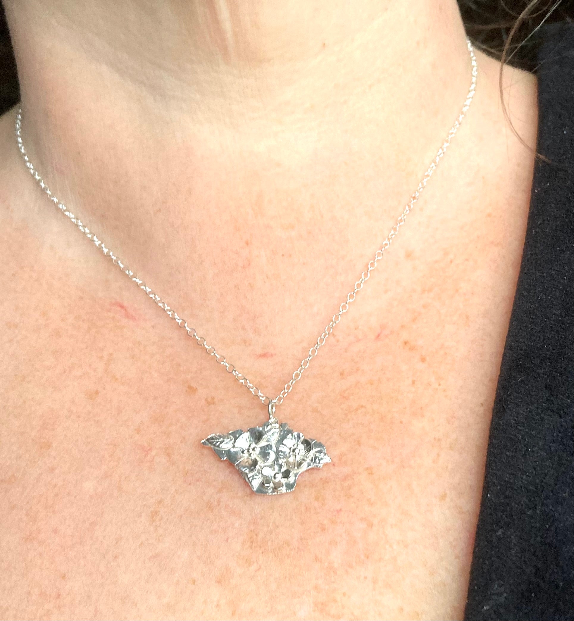 floral Isle of Wight pendant worn on woman's neck