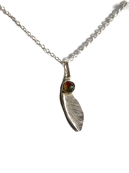 handmade textured  silver sycamore seed pendant by Kim Styles Jewellery set with round cabochon agate on white background