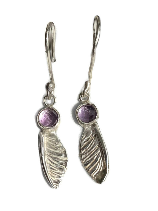 handmade textured  silver sycamore seed earrings by Kim Styles Jewellery set with round chequerboard cut amethysts, on white background