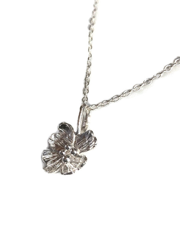 A silver flower pendant necklace by Kim Styles Jewellery, on a delicate silver chain, photographed against a solid white background.