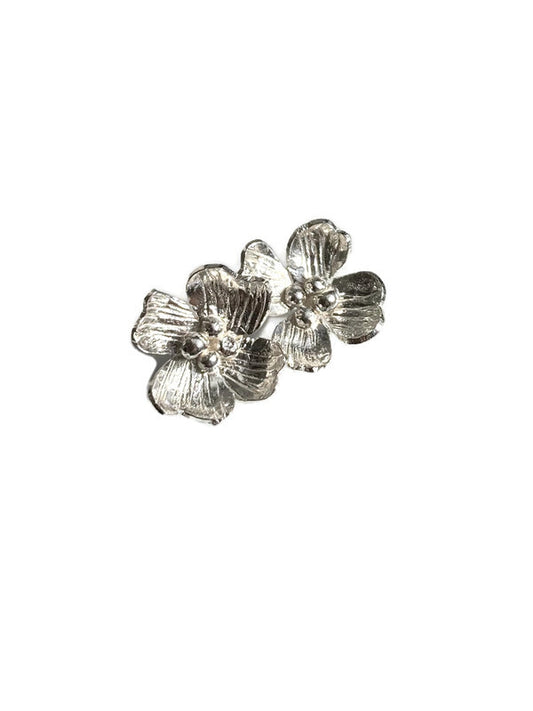 A pair of dogwood blossom floral stud earrings with engraved texture, on a white background